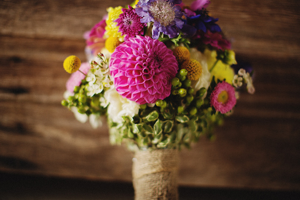 Colorful and rustic bridal bouquet featuring shades of bright pink, yellow and green - Photo by Ryan Flynn Photography